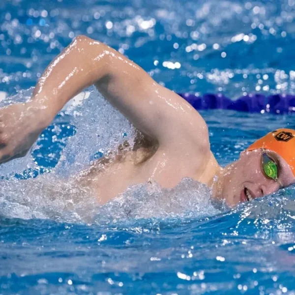 swimmer for beginners with orange bathing cap crawling thru the water