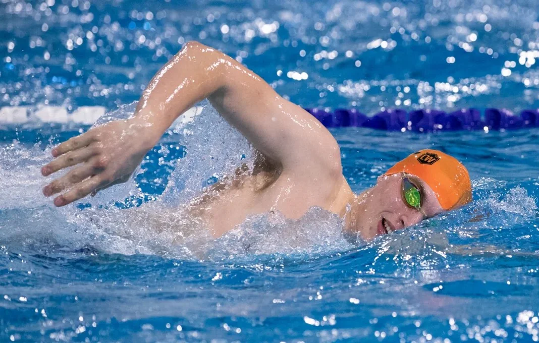 swimmer for beginners with orange bathing cap crawling thru the water