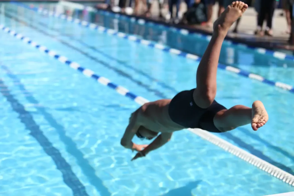 swimmer jumps in the water from start